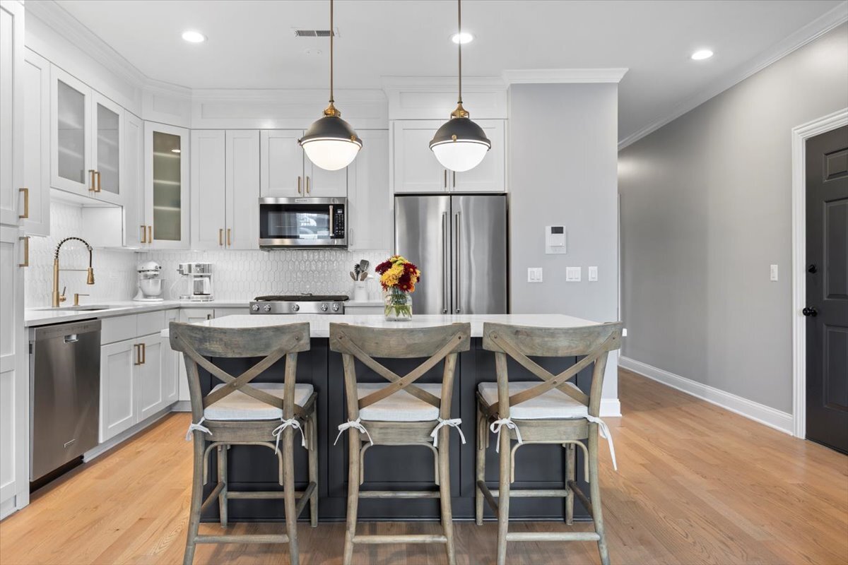 2463 West Foster Avenue, Unit 3 Chicago, IL 60625 - Photo 10 of 31 a kitchen with stainless steel appliances a dining table chairs sink and cabinets
