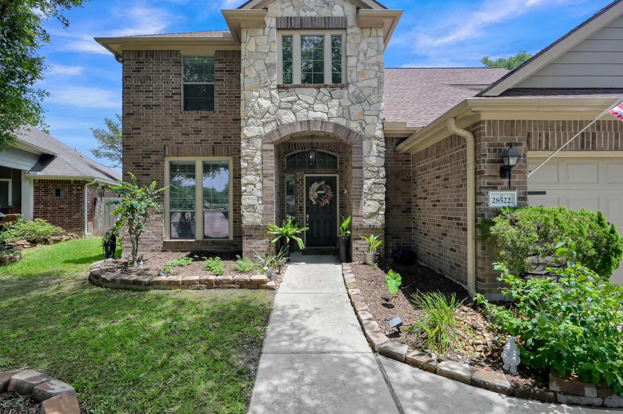28522 Misty Cliff Lane Spring, TX 77386 - Photo 2 of 12 Grand front entry with soaring architecture, stone detailing, and a welcoming covered porch. Beautiful landscaping and a private walkway create an impressive first impression.