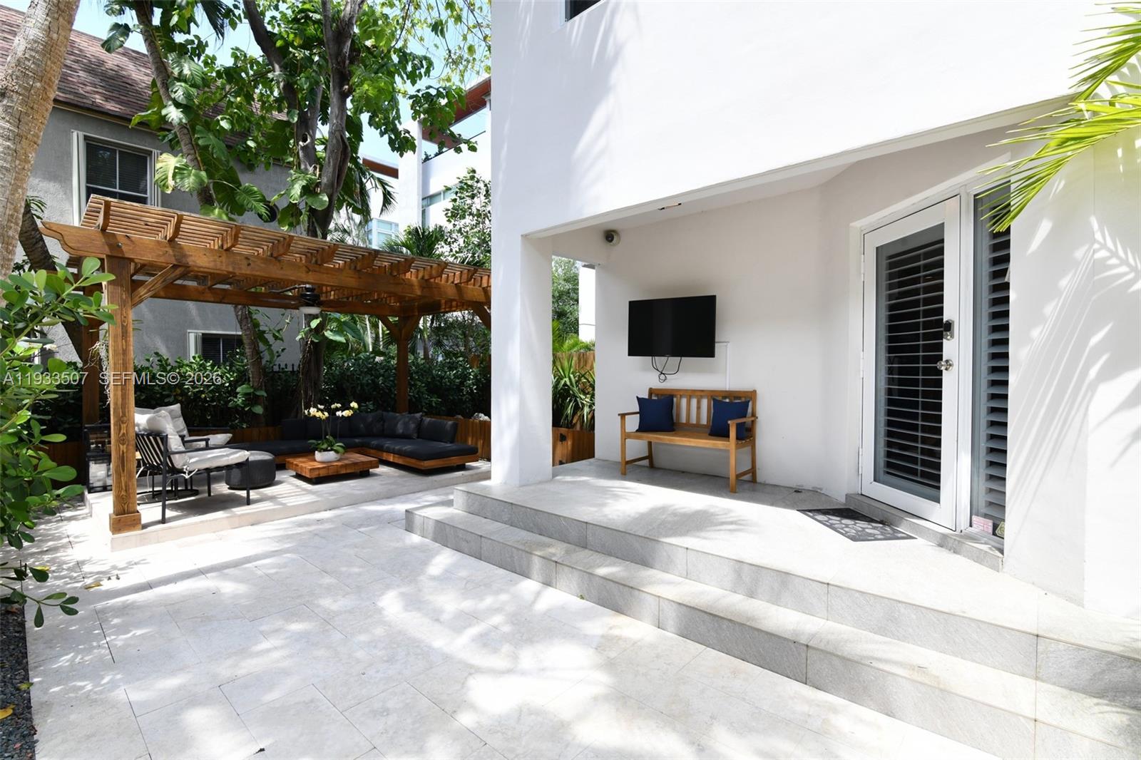 2918 Bird Avenue, Unit 5 Miami, FL 33133 - Photo 16 of 29 a view of a patio with a table and chairs under an umbrella with a couch