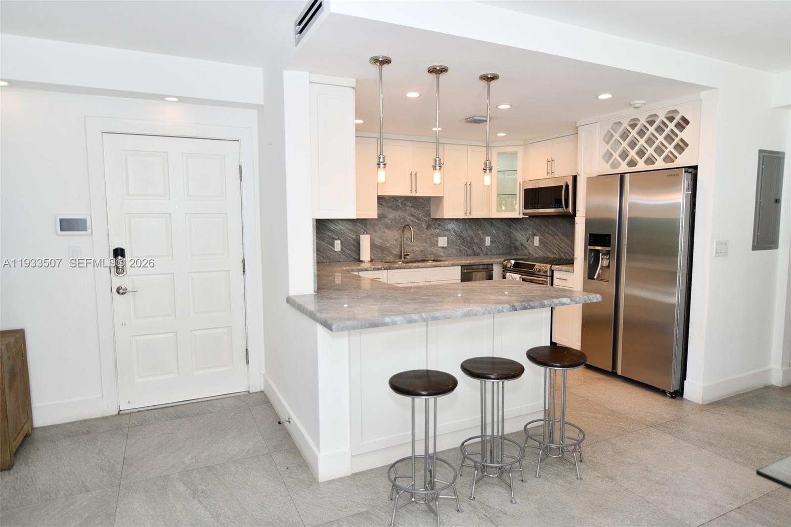 2918 Bird Avenue, Unit 5 Miami, FL 33133 - Photo 2 of 29 a kitchen with stainless steel appliances granite countertop a refrigerator a sink a stove a dining table and chairs