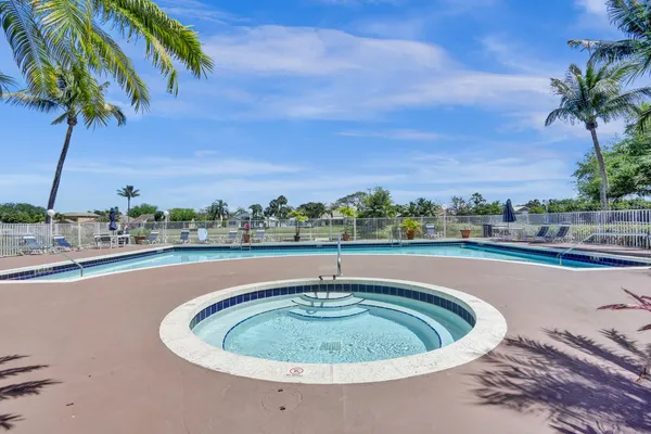 a view of a swimming pool with a lawn chairs and a fire pit