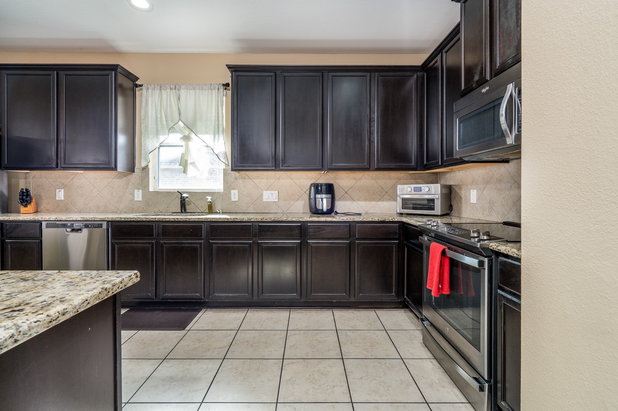 18879 Atascosa Trail Magnolia, TX 77355 - Photo 9 of 25 a kitchen with stainless steel appliances granite countertop a sink stove and cabinets