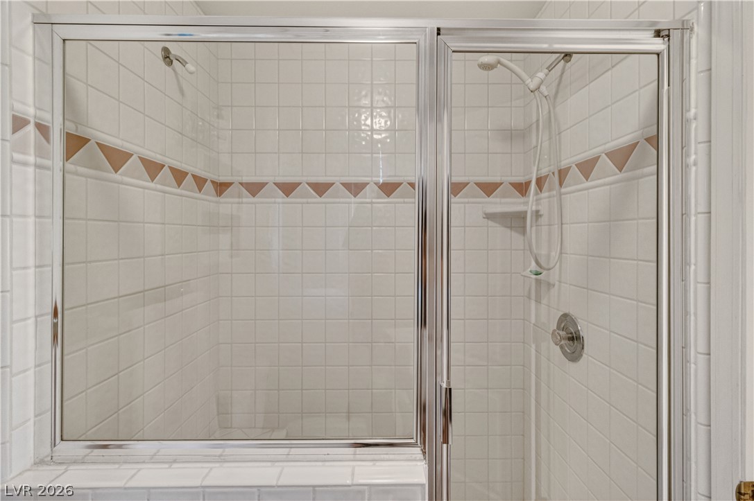 2055 Cholla Way Laughlin, NV 89029 - Photo 38 of 87 A well-maintained shower enclosure features white tiled walls and a decorative accent border.