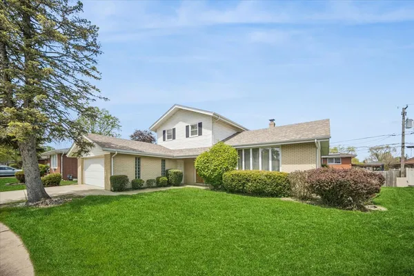 a front view of a house with a garden and yard