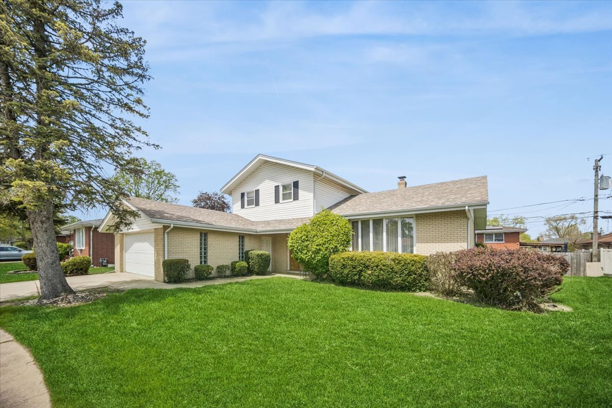 2316 185th Place Lansing, IL 60438 - Photo 1 of 21 a front view of a house with a garden and yard
