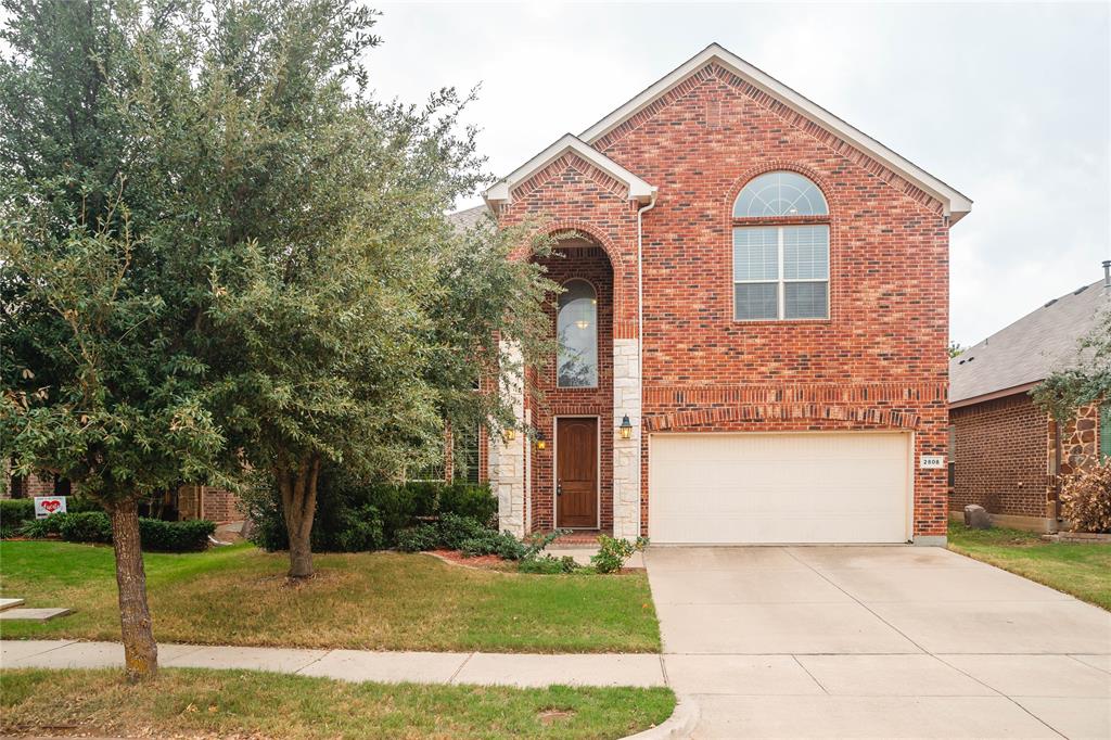 2808 Frontier Drive Denton, TX 76210 - Photo 1 of 1 Traditional-style home with brick siding, an attached garage, a front lawn, and concrete driveway