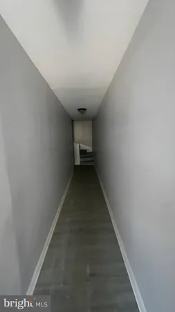 an empty room with wooden floor fireplace and windows