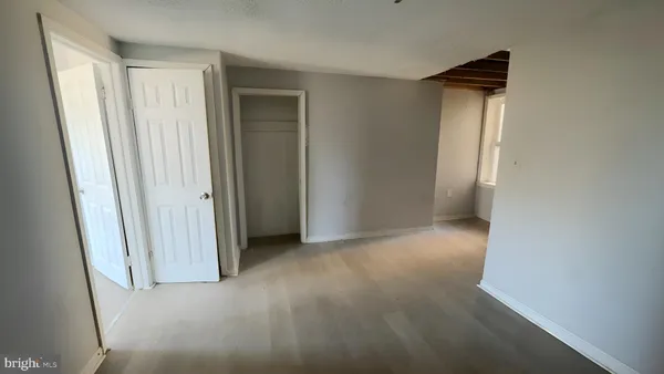 an empty room with closet and a window