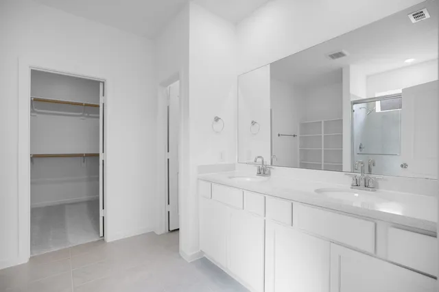 a bathroom with double sink and a mirror