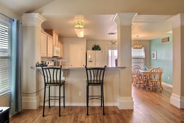 a view of a a dining room with furniture window and wooden floor