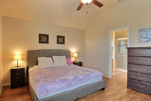 a bedroom with a bed and a ceiling fan