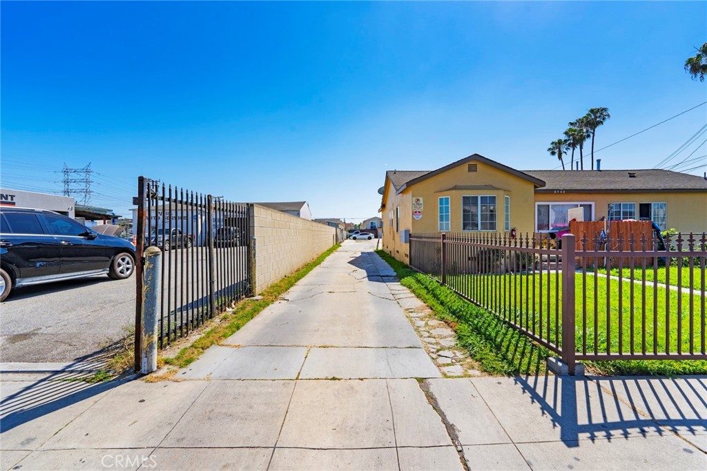 a view of a brick house with wooden fence