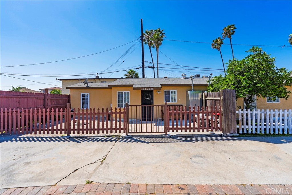 8564 Artesia Boulevard Bellflower, CA 90706 - Photo 6 of 20 a view of a house with a small yard and wooden fence