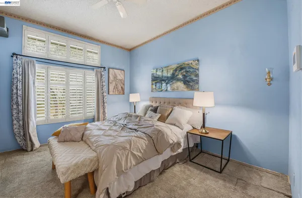 a bedroom with a bed and a painting on the wall