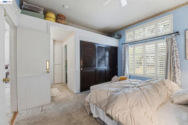 a bedroom with a bed and a large mirror