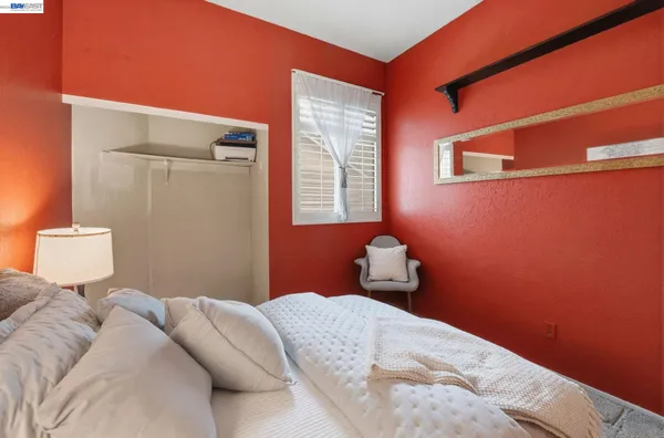 a bedroom with a bed and a lamp with the window