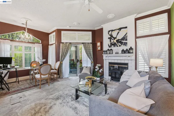 a living room with furniture a fireplace and a large window