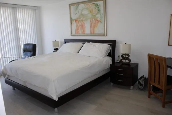 a bed sitting in a bedroom next to a window with tv