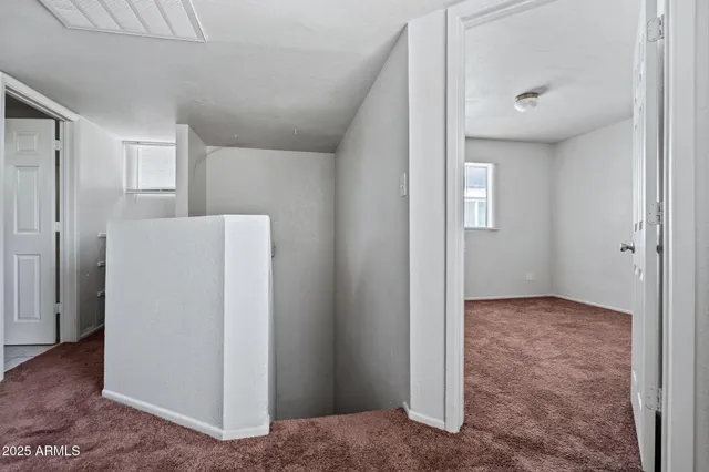 a view of a hallway to rooms