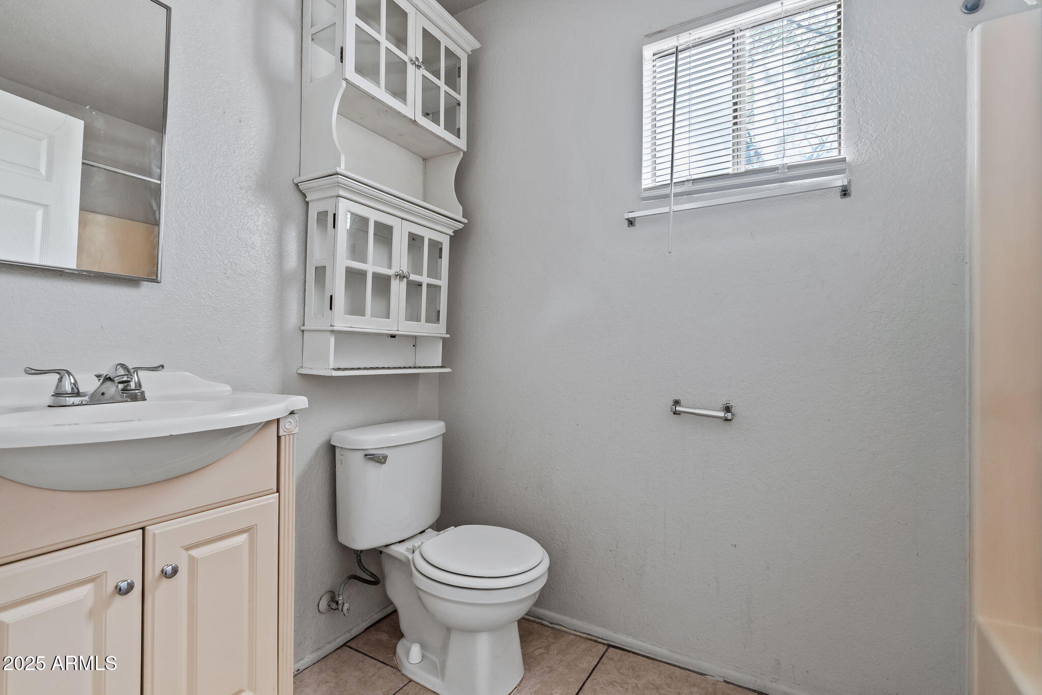 1742 East Pepper Circle, Unit 2 Mesa, AZ 85203 - Photo 17 of 26 a bathroom with a granite countertop toilet a sink and a window