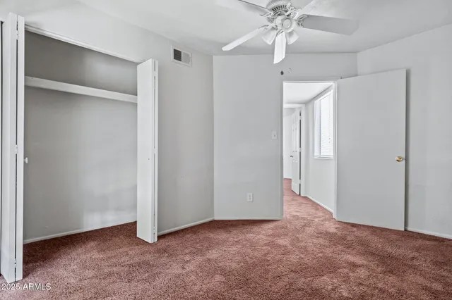 a view of an empty room with a ceiling fan