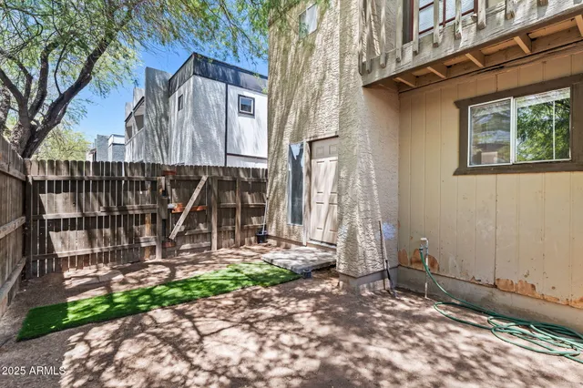 a view of a house with a yard and a wooden fence