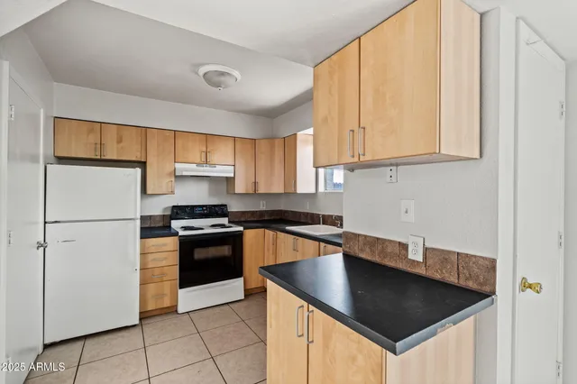 a kitchen with granite countertop a sink stainless steel appliances and cabinets