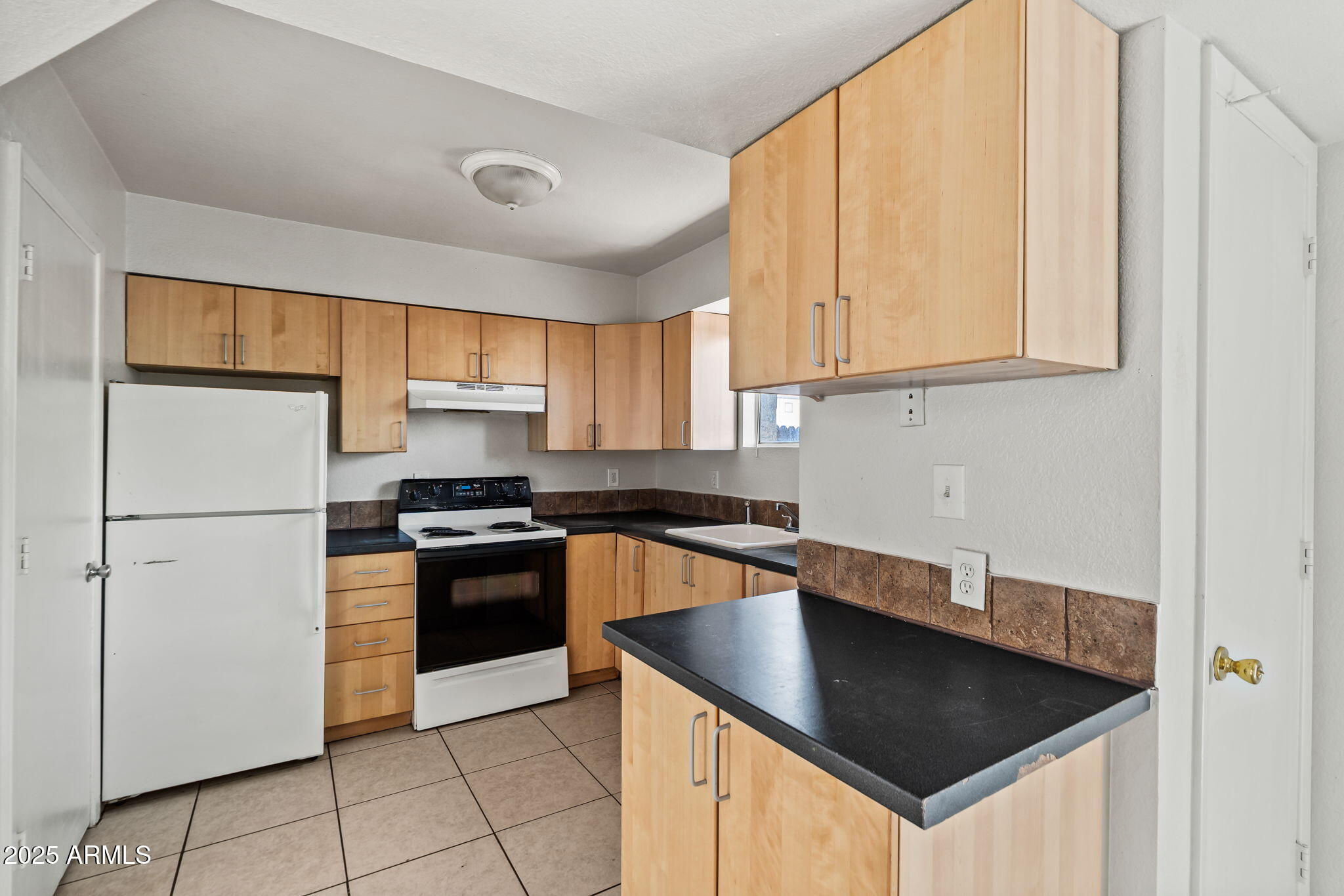 1742 East Pepper Circle, Unit 2 Mesa, AZ 85203 - Photo 7 of 26 a kitchen with granite countertop a sink stainless steel appliances and cabinets