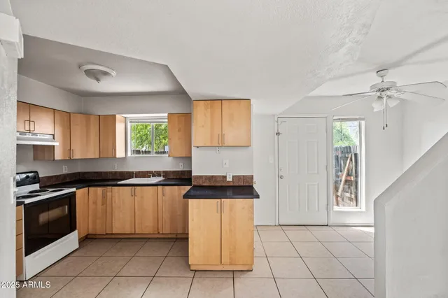 a kitchen with granite countertop a stove top oven sink and cabinets