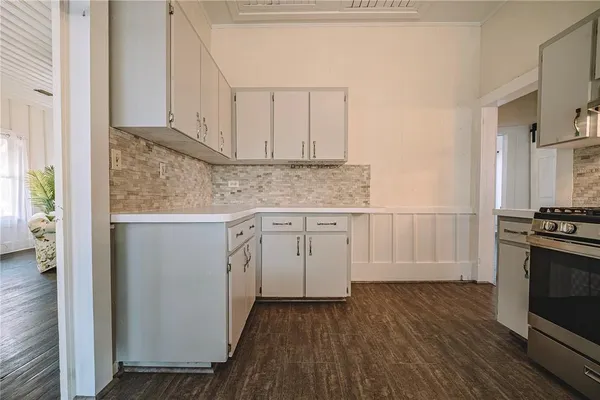 a kitchen with granite countertop a sink stove and cabinets