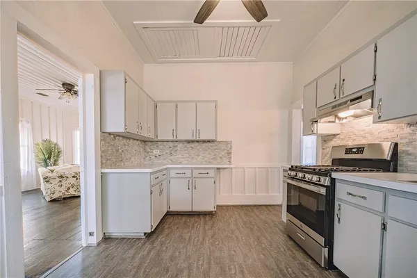 a kitchen with granite countertop white cabinets and white appliances