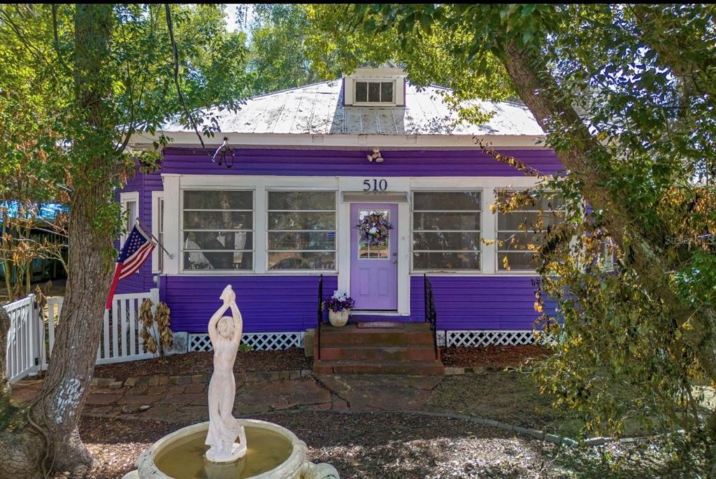 510 East Key Avenue Eustis, FL 32726 - Photo 3 of 40 a front view of a house with a yard fire pit and outdoor seating