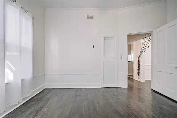 a view of an empty room with wooden floor