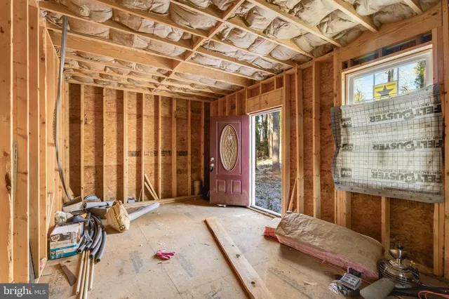 a bedroom with a bed and large windows