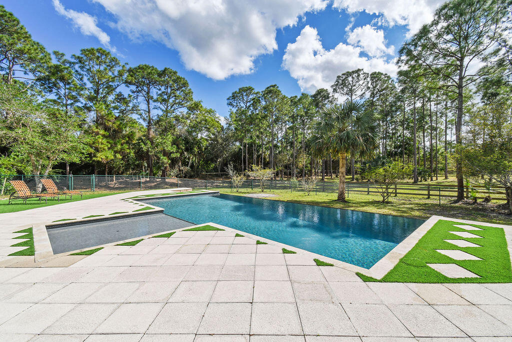 10792 Randolph Siding Road Jupiter, FL 33478 - Photo 18 of 55 a view of a swimming pool with a yard and sitting area