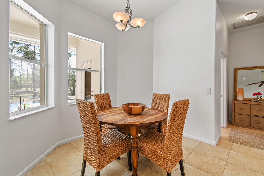 10792 Randolph Siding Road Jupiter, FL 33478 - Photo 35 of 55 a dining room with furniture a chandelier and window