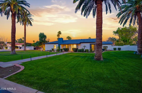 a view of a apartment with a big yard and palm trees