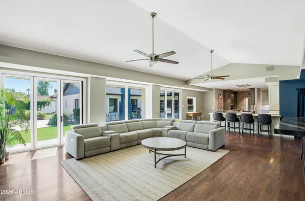 a living room with furniture ceiling fan and a large window
