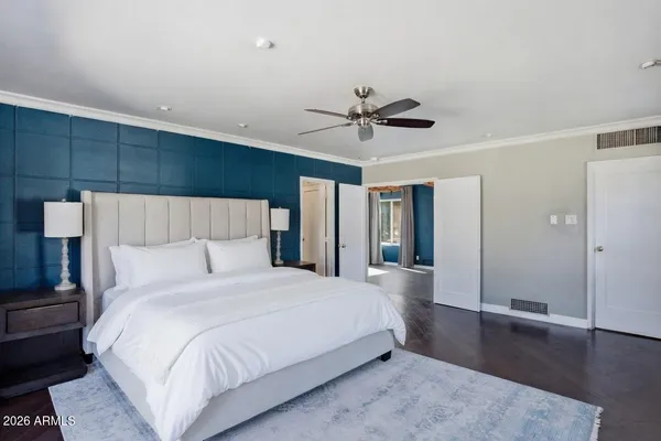 a spacious bedroom with a large bed and a chandelier
