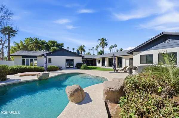 a view of a house with swimming pool and sitting area