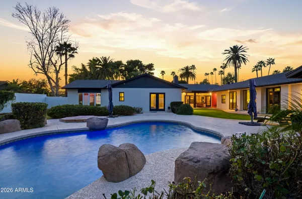 a front view of a house with yard swimming pool and outdoor seating