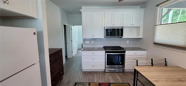 a kitchen with a refrigerator and a stove top oven