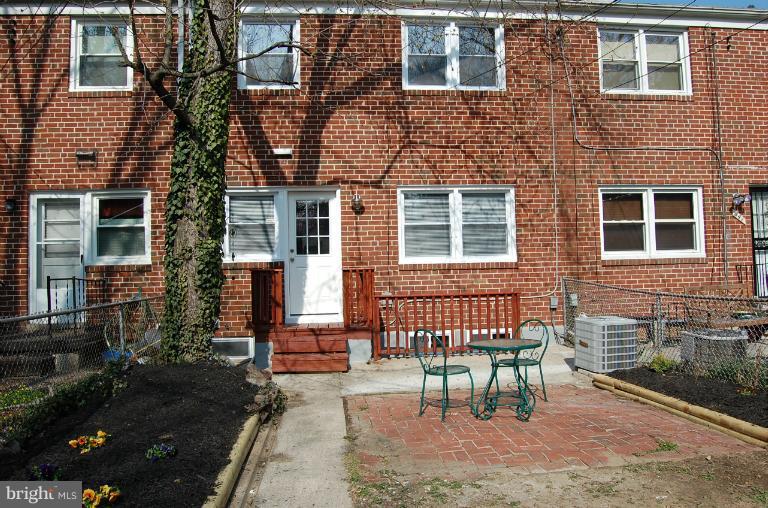 839 Reverdy Road Baltimore, MD 21212 - Photo 4 of 16 a view of a brick house with a bench next to a yard