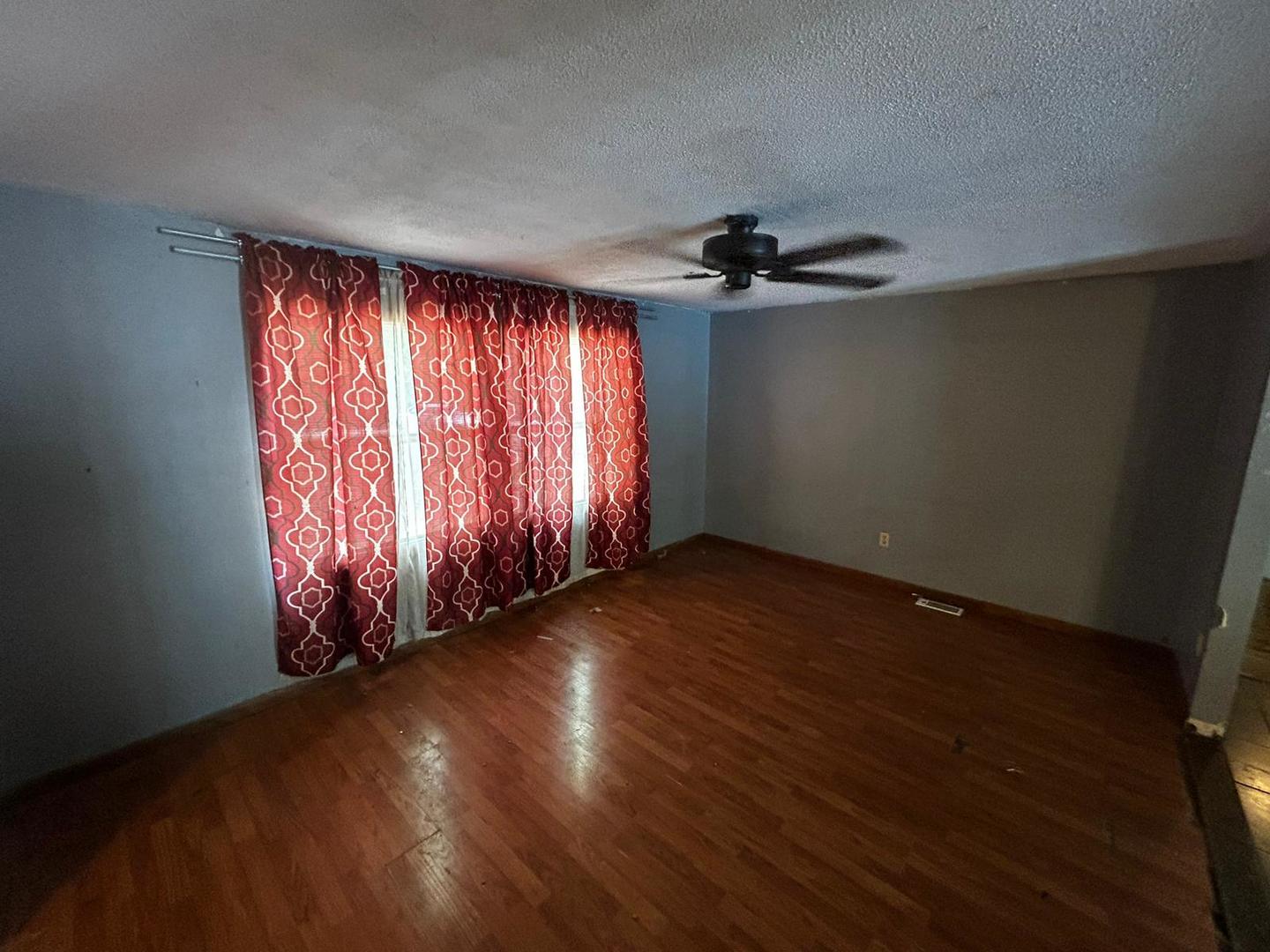 3073 Hotze Road Salem, IL 62881 - Photo 6 of 20 an empty room with wooden floor fan and windows