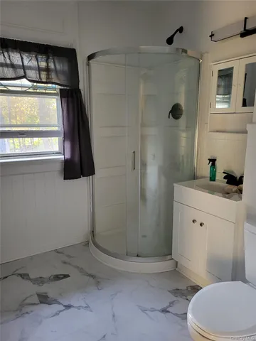 a bathroom with a shower a toilet and sink