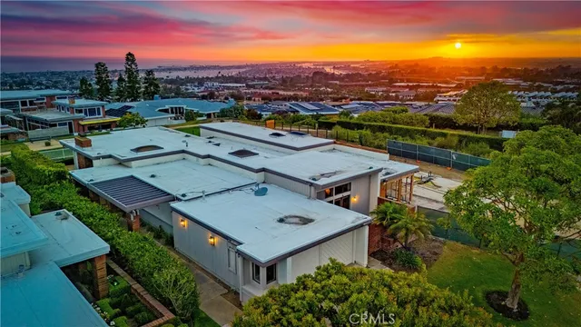 an aerial view of a city with lots of residential buildings ocean and mountain view in back