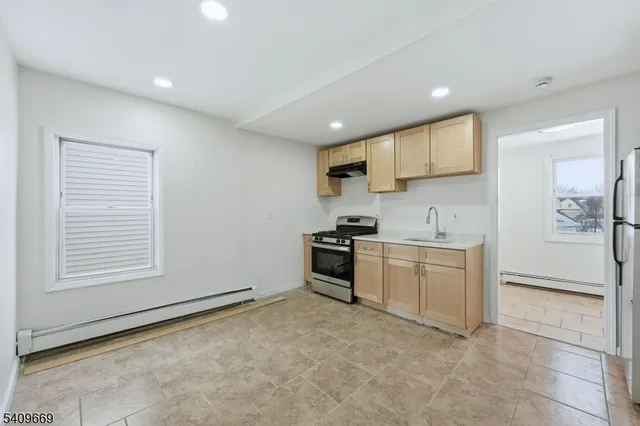 a kitchen with a refrigerator and white cabinets