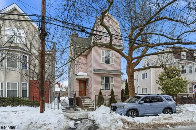 a front view of a house with cars parked