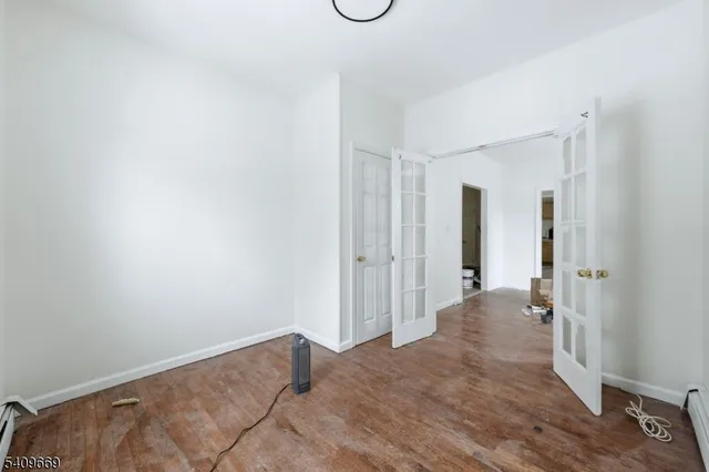 a view of a room with wooden floor and tub