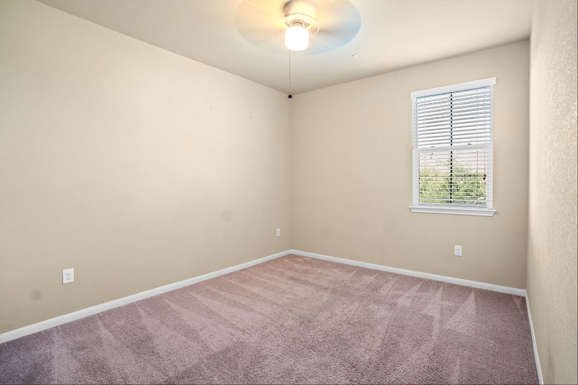 2880 Donnell Drive, Unit 2003 Round Rock, TX 78664 - Photo 14 of 27 an empty room with a chandelier fan and windows